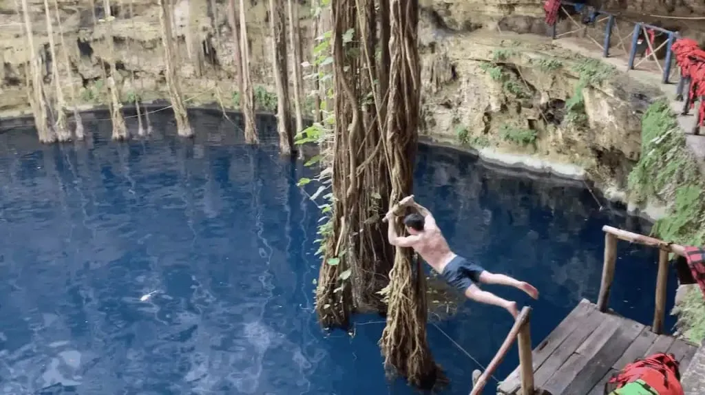 Swimmers in the open Cenote Oxman chamber below the hacienda grounds