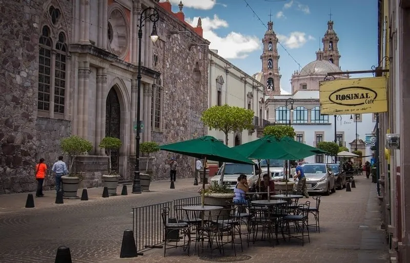 San Marcos garden walkway in Aguascalientes with spring trees, plaza paths, and warm central Mexico light