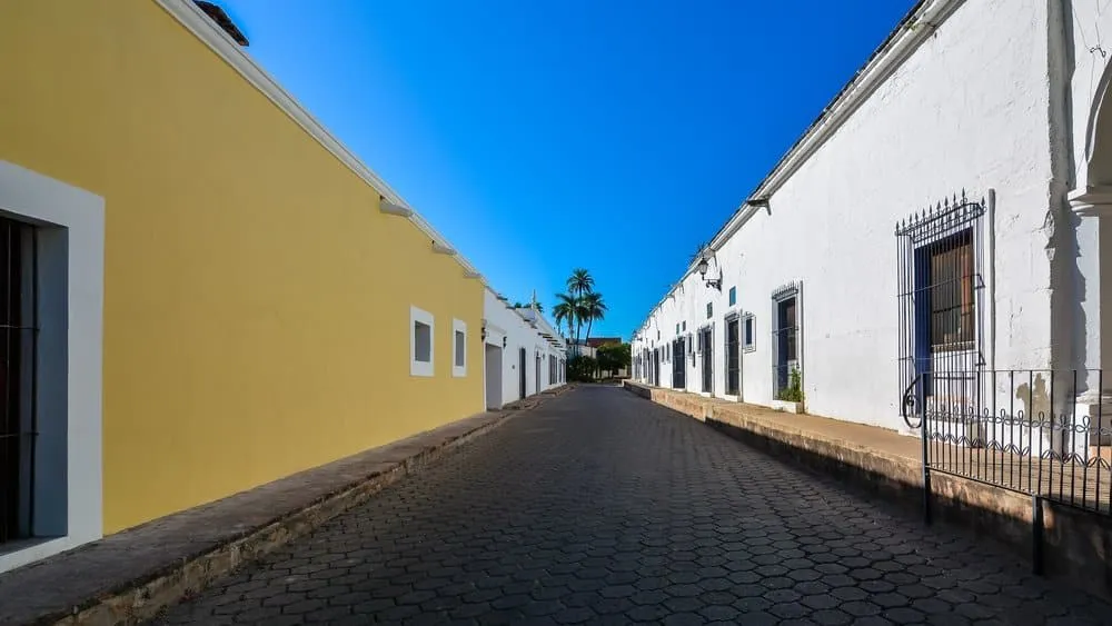 Arched colonial portico opening onto an Álamos street