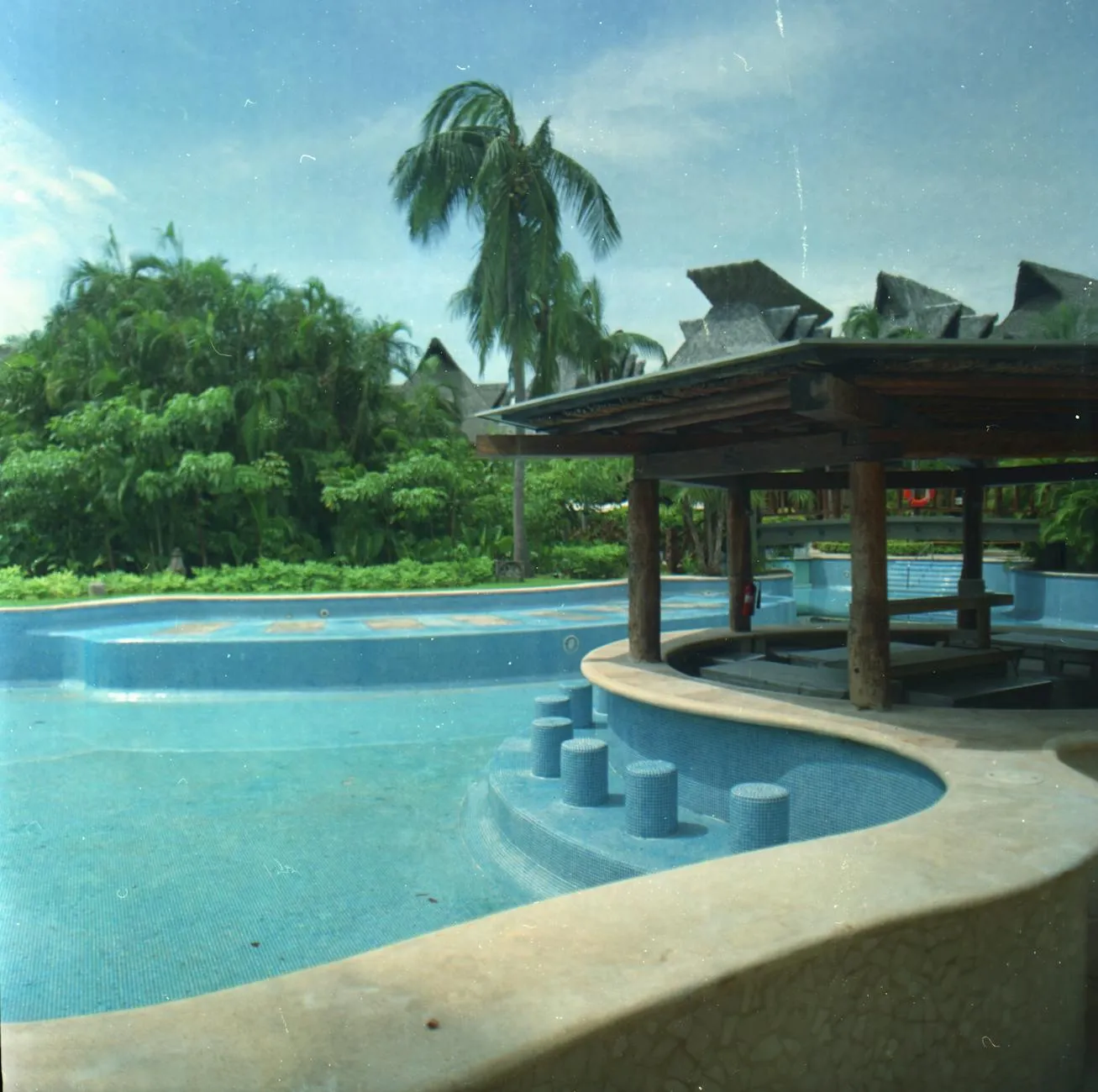 Swim-up bar at a Mexican all-inclusive resort with guests enjoying tropical drinks in a turquoise pool