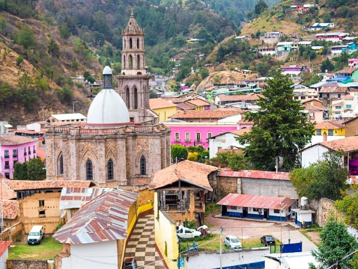 The colonial mountain town of Angangueo in Michoacán, gateway to the Monarch butterfly reserves — cobblestone streets climbing steep pine-covered hillsides