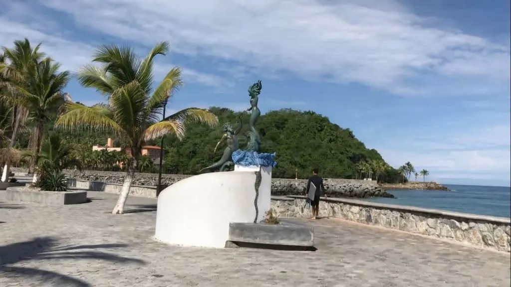 Seafront promenade in Barra de Navidad with fishing boats offshore
