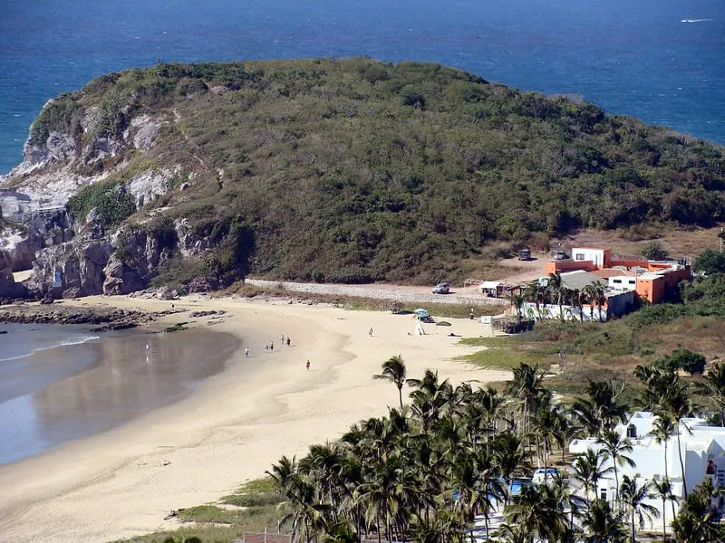 Playa Brujas shoreline in Mazatlan with open sand, surf, and coastal hills