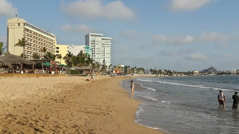 Mazatlan Playa Norte beach with calm Pacific ocean water and beach umbrellas along the coast in Sinaloa Mexico