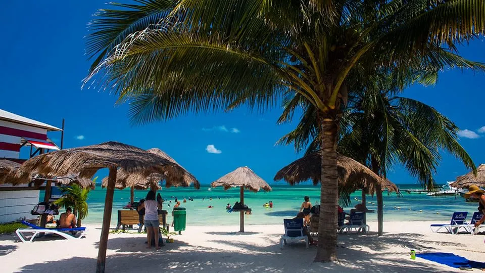 Las Perlas beach in Cancun with calm shallow water and palapas