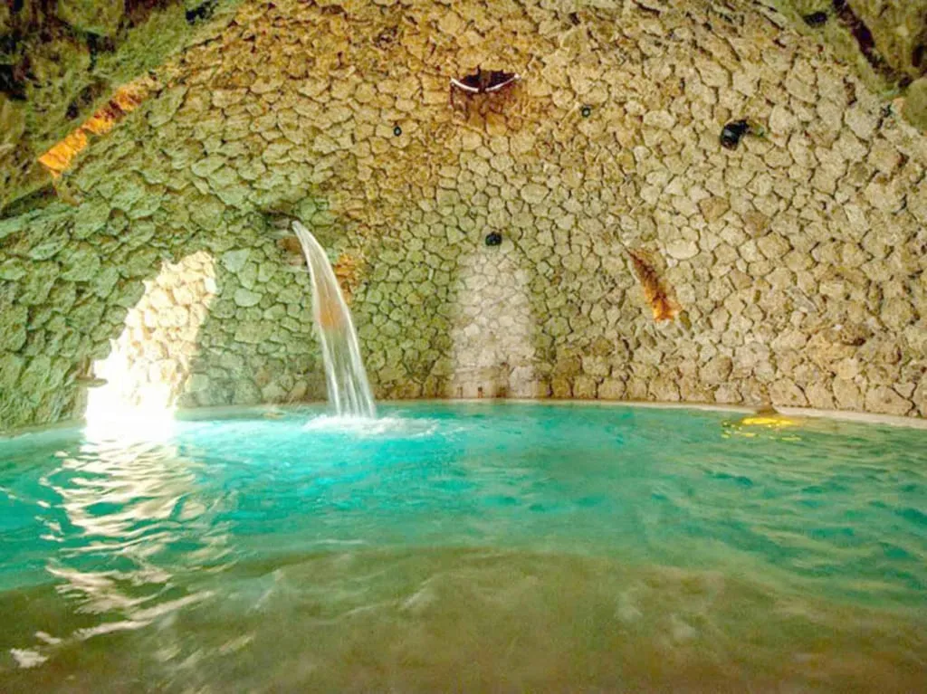 Mayan Baths hot springs near San Miguel de Allende — steaming thermal pool surrounded by stone walls and tropical vegetation in Guanajuato state