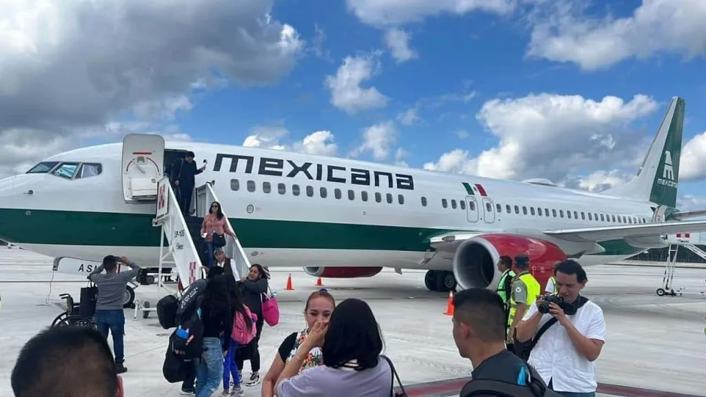 Mexicana airplane parked at a passenger gate