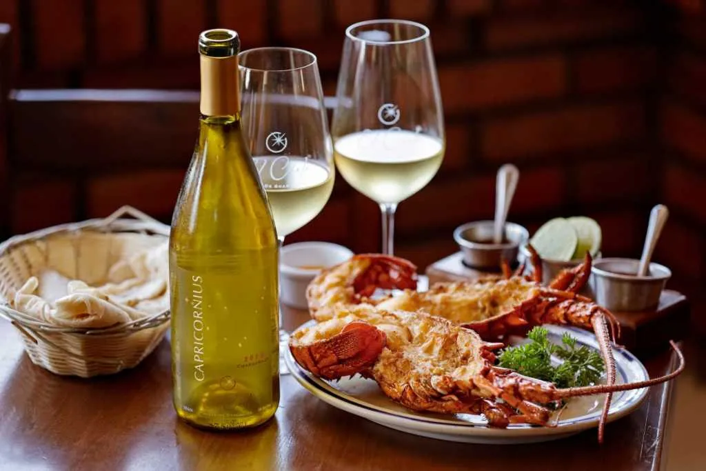 White wine bottle with lobster and two glasses