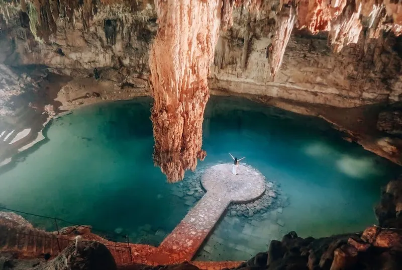 Cenote Suytun platform beneath a circular shaft of light