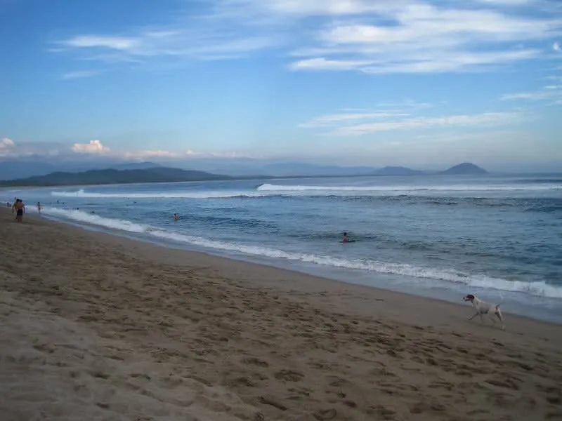 Wide Pacific beach in Chacahua with palapas along the sand