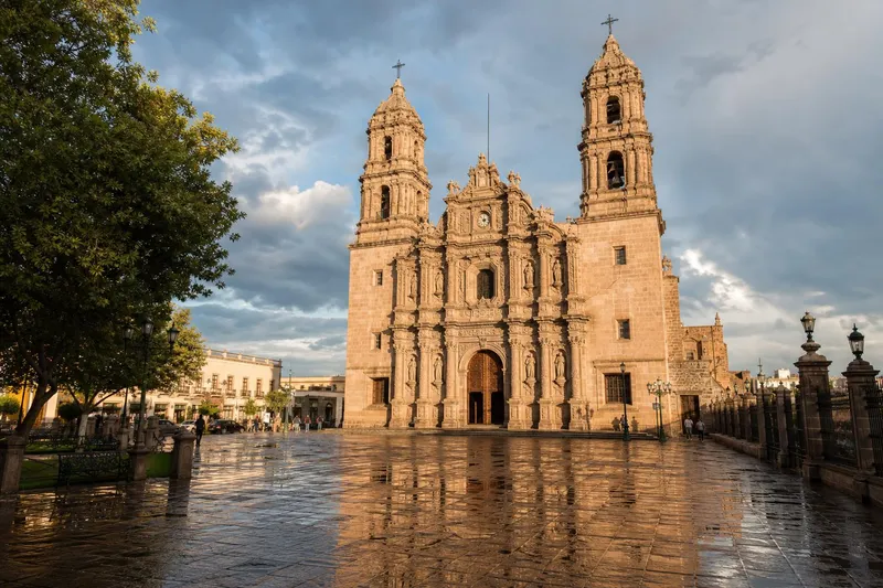 Chihuahua City cathedral after an August rain with wet plaza stones and northern Mexico summer storm clouds