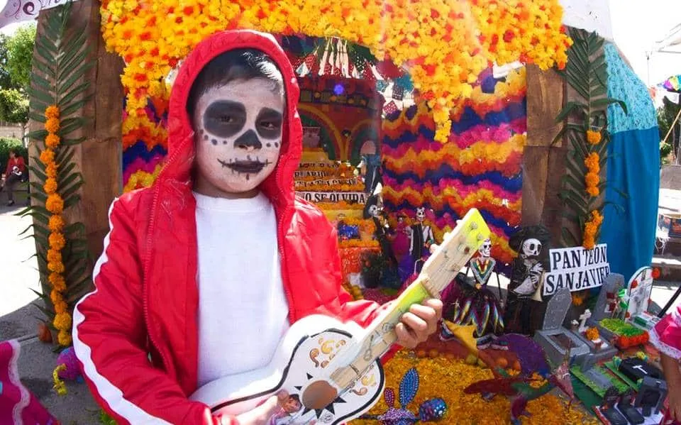 Miguel from Coco costume with red hoodie guitar and skull makeup