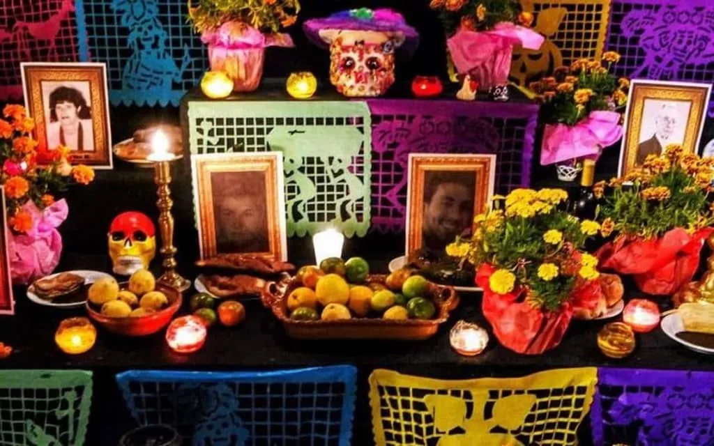 Framed family photographs surrounded by marigolds on an ofrenda