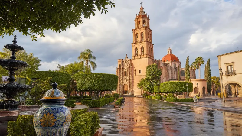 Dolores Hidalgo parish plaza under green-season June clouds in Guanajuato