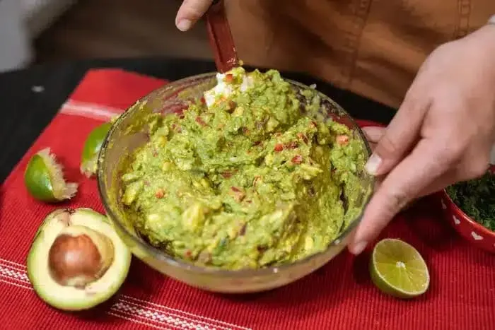 Ripe Mexican avocado halves beside whole green avocados
