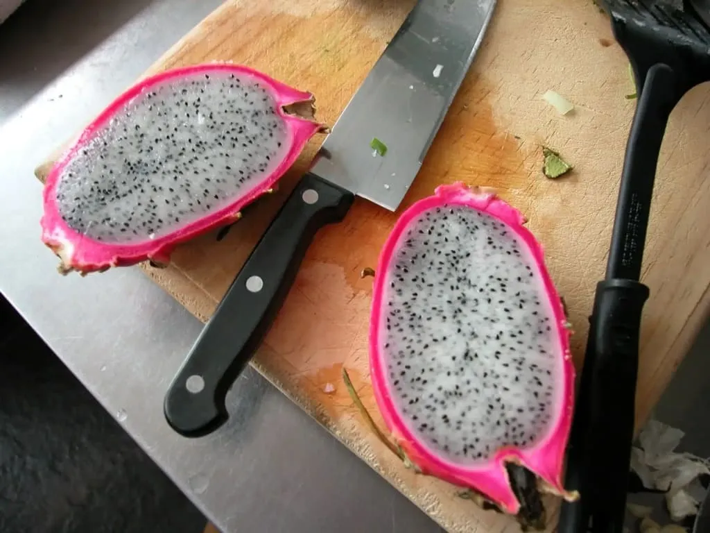 Bright pink pitahaya dragon fruit with white speckled flesh