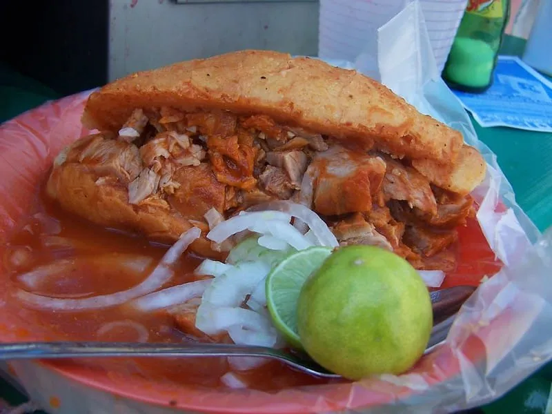 Torta ahogada in Guadalajara — the city's signature street food of pork in salsa-soaked birote bread