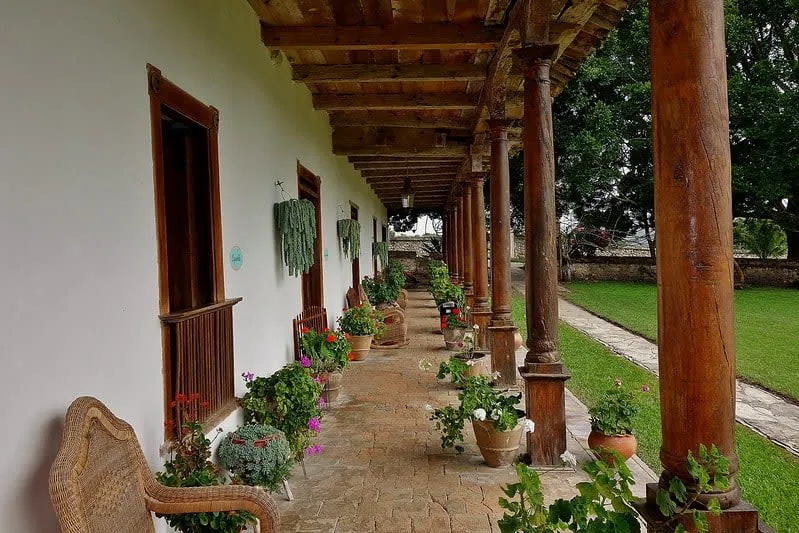 Historic hacienda facade with red roof tiles and open garden walkways
