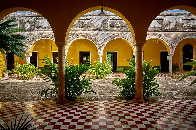 Yucatan hacienda building framed by palms and low stone walls