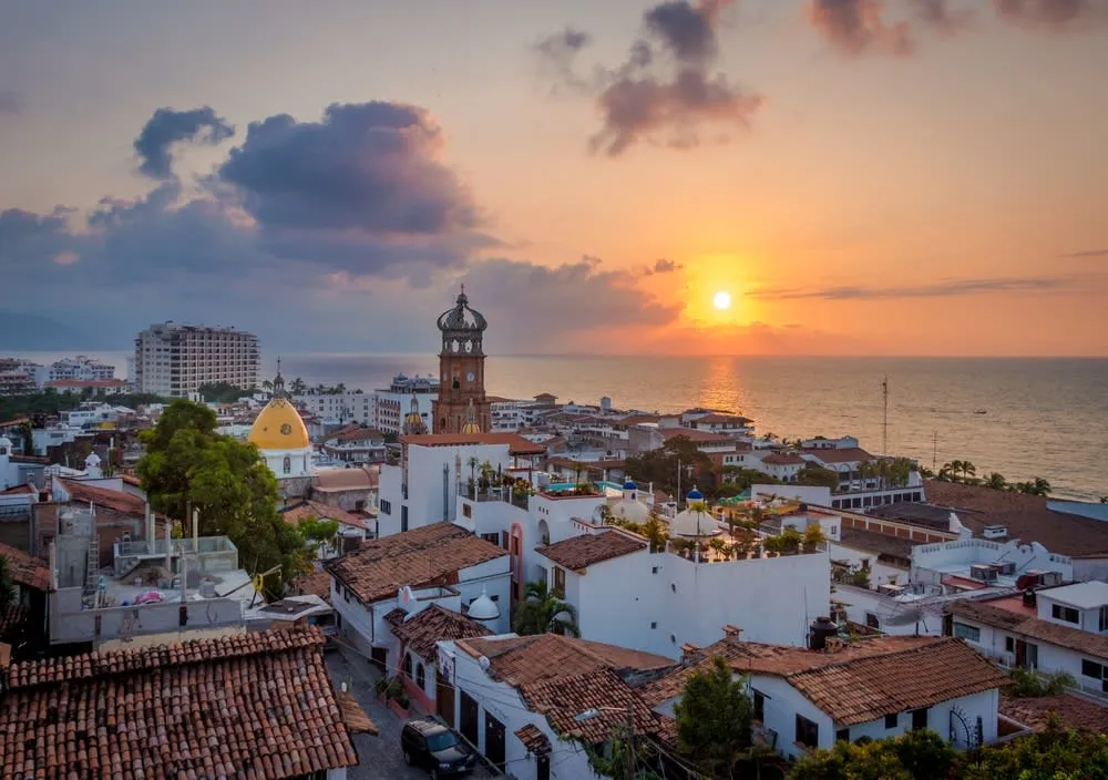 Puerto Vallarta beach at sunset with couples walking near the water