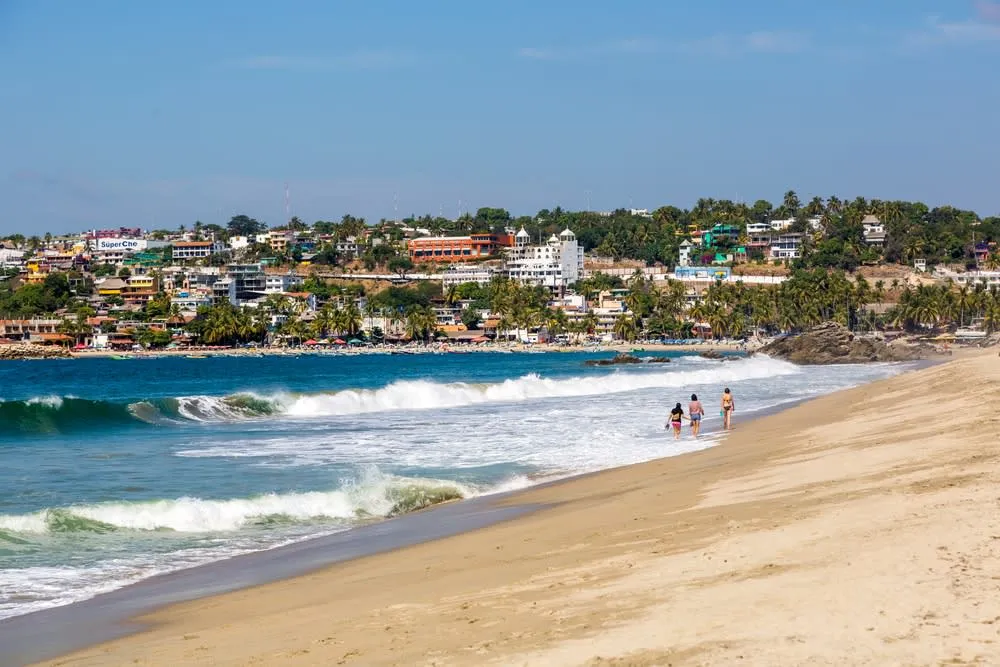 Puerto Escondido beach with rocky cliffs and Pacific waves