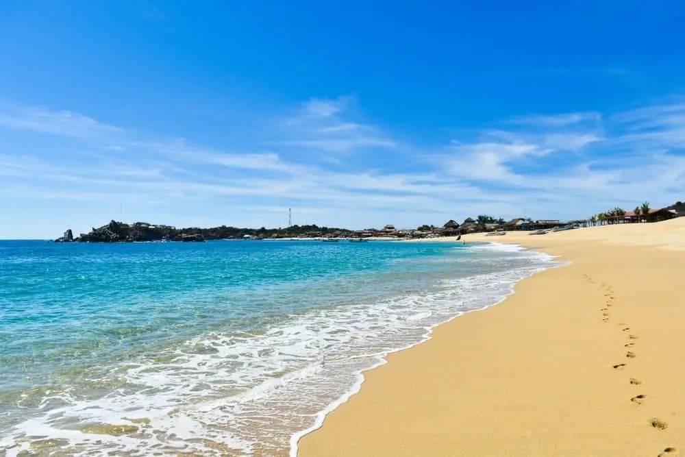 San Agustín Bay in Huatulco showing calm turquoise waters with fishing boats and the Pacific horizon
