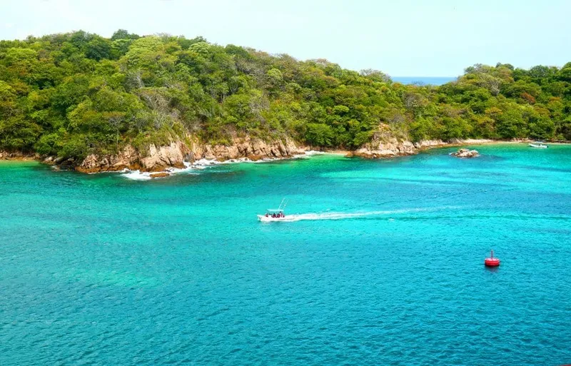 Santa Cruz Bay beach with small boats and calm water in Huatulco