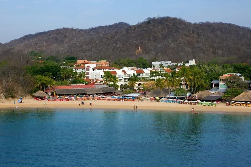 La Crucecita street scene with palms and low buildings near Huatulco's bays