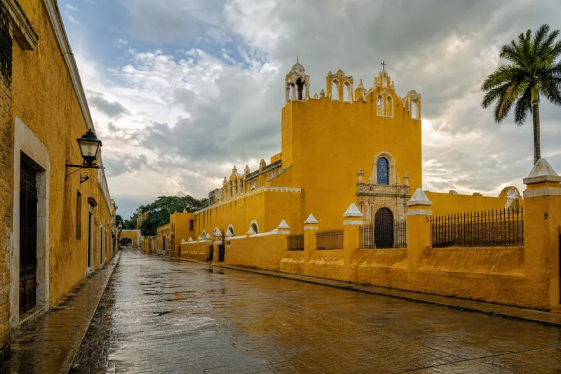 Yellow colonial street and convent view in Izamal during July rainy-season travel