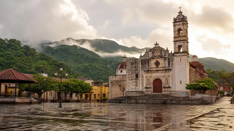 Jalpan de Serra mission in June with green Sierra Gorda hills, morning light, and rainy-season clouds