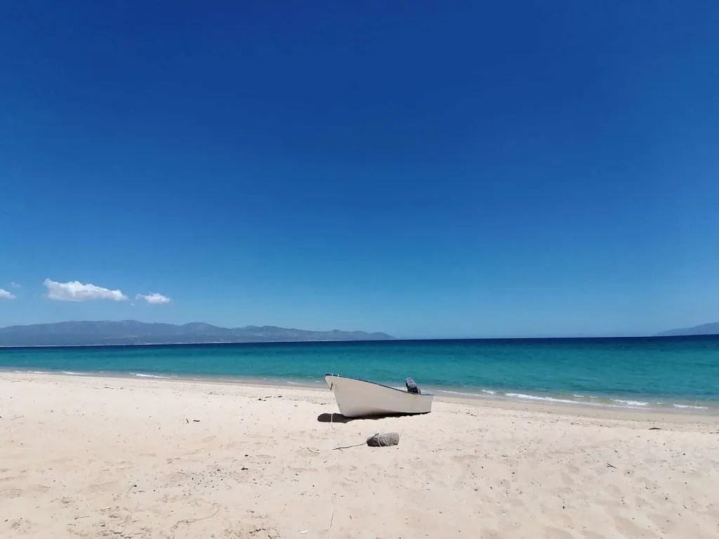 Quiet turquoise beach along La Ventana Bay with desert hills behind the shore
