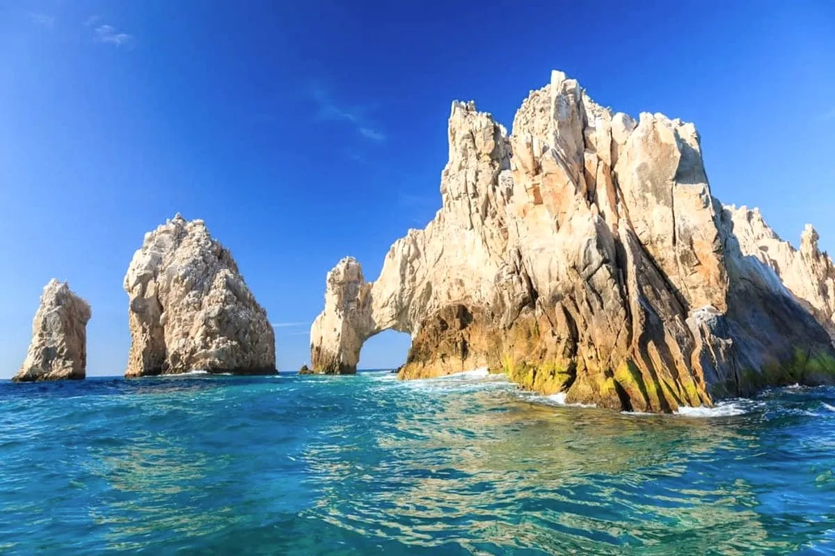 Blue Sea of Cortez water, rocky islands, and ocher Baja desert cliffs under clear winter light