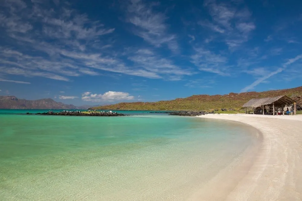 Clear Sea of Cortez water below dry desert slopes and rocky Baja shoreline