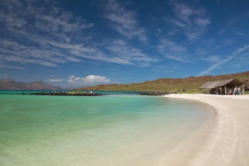 Rocky Baja shoreline curving into blue Sea of Cortez water below dry hills