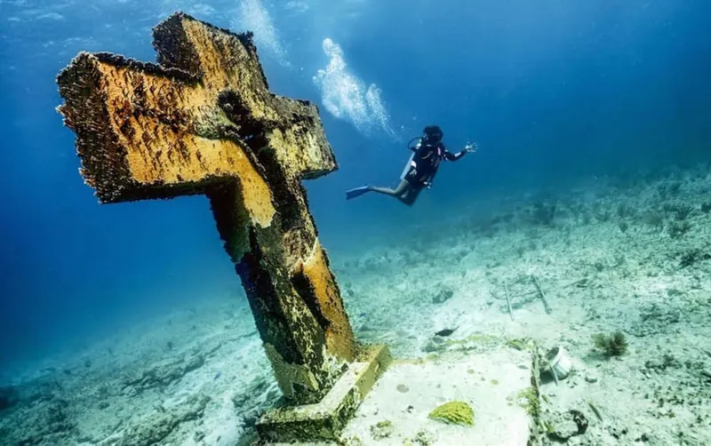 Snorkeler exploring Manchones Reef underwater near Isla Mujeres with colorful coral and tropical fish