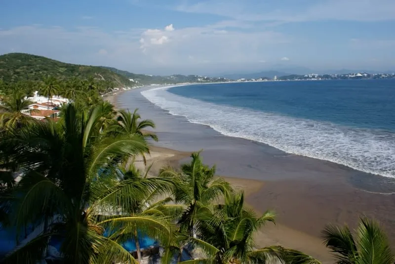 La Boquita beach near Manzanillo with palapas, sand, and calm Pacific water after summer rain