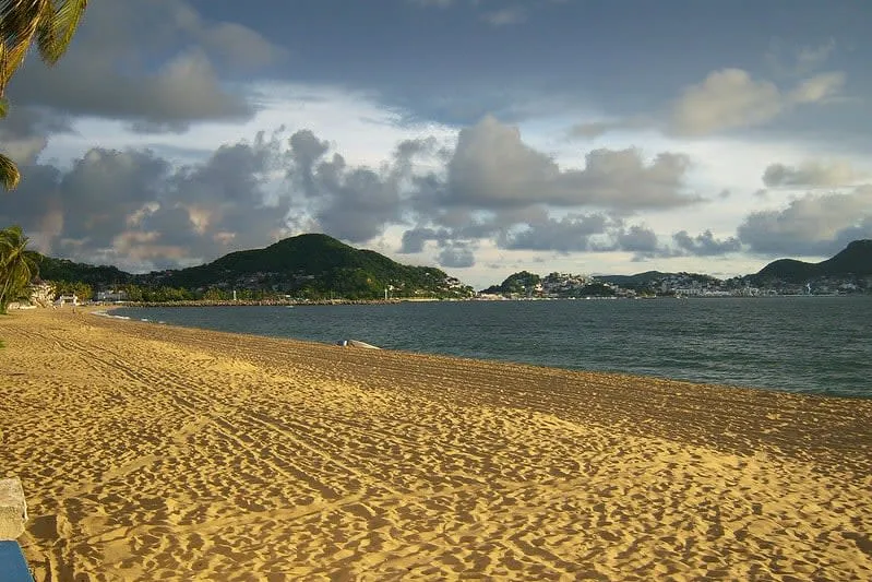 Las Brisas Beach with light brown sand and calmer Manzanillo Bay water