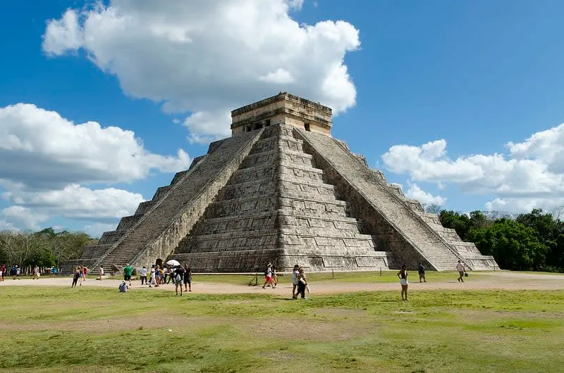 Large stone Mayan pyramid with tourists in front
