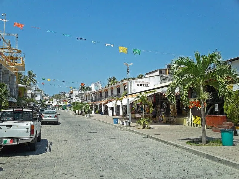 El Adoquin pedestrian street at golden hour with cafes, shops, and street vendors