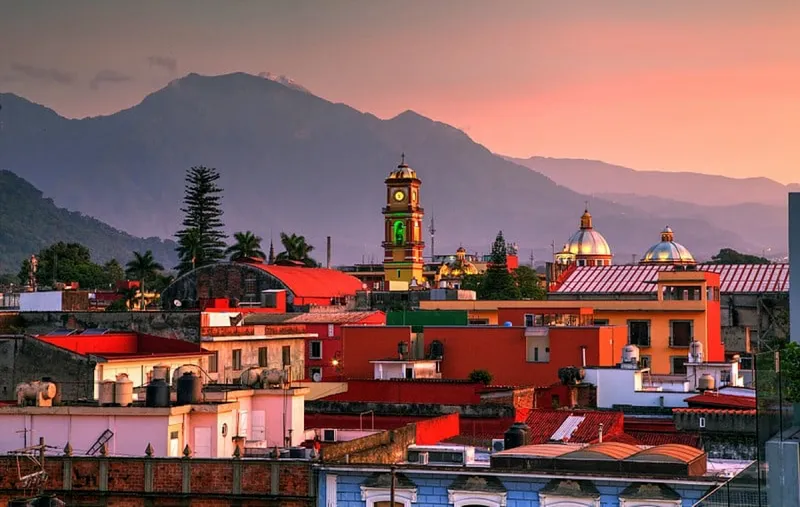 Morning sunlight on Orizaba rooftops with Pico de Orizaba beyond the valley