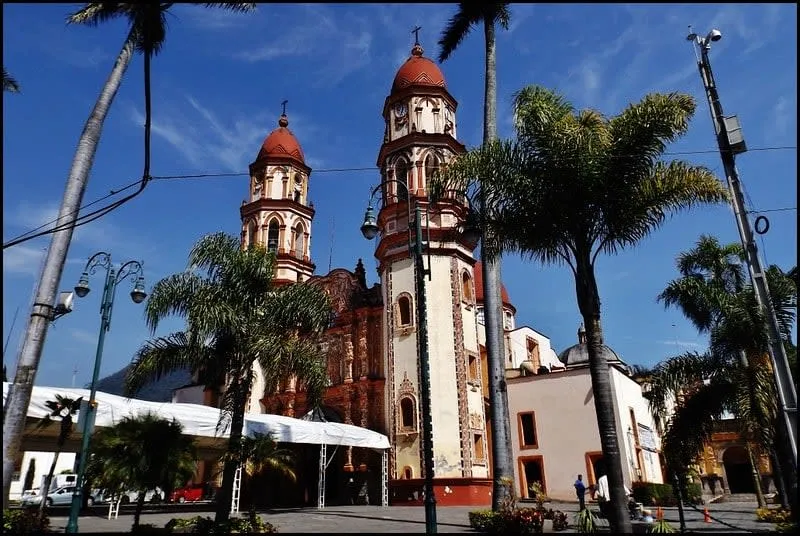 Colorful street scene in Orizaba with colonial buildings below the surrounding hills