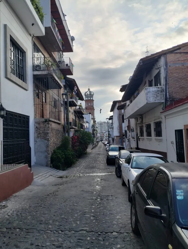 Puerto Vallarta church tower above red-tiled rooftops on a humid summer day