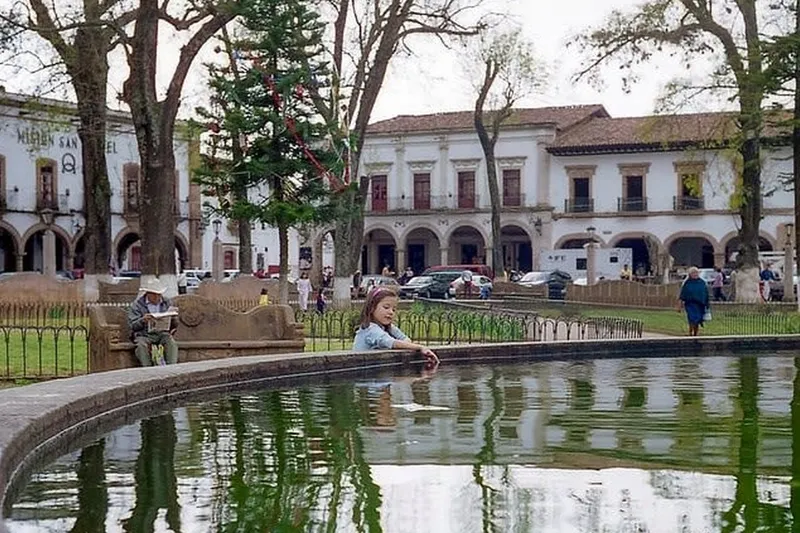 Pátzcuaro colonial arcades and plaza trees in October light