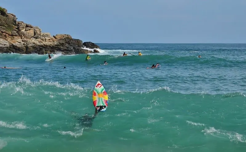 Beginner surfers waiting on gentle waves inside the bay
