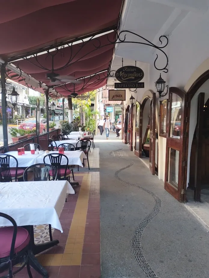 Romantic Zone street near the Malecon with colorful storefronts, cafe tables, and evening pedestrians