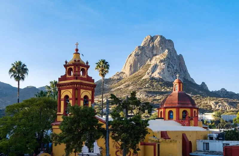 Pena de Bernal monolith rising above red-roofed houses in Queretaro