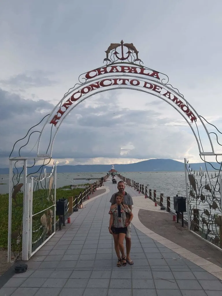 Chapala malecon walkway beside the lake with shops, benches, and sunset-view seating nearby