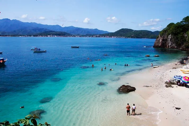 Calm water and anchored boats on the beach at Rincon de Guayabitos