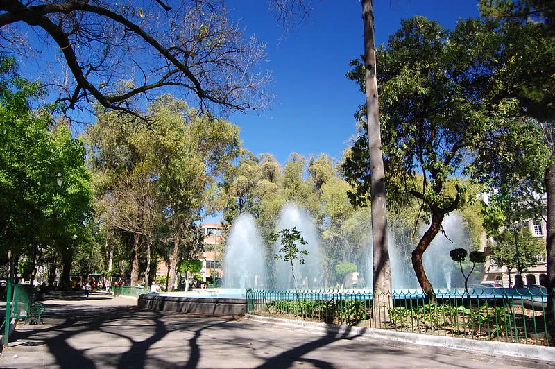 Fountain spraying water in a tree-lined plaza