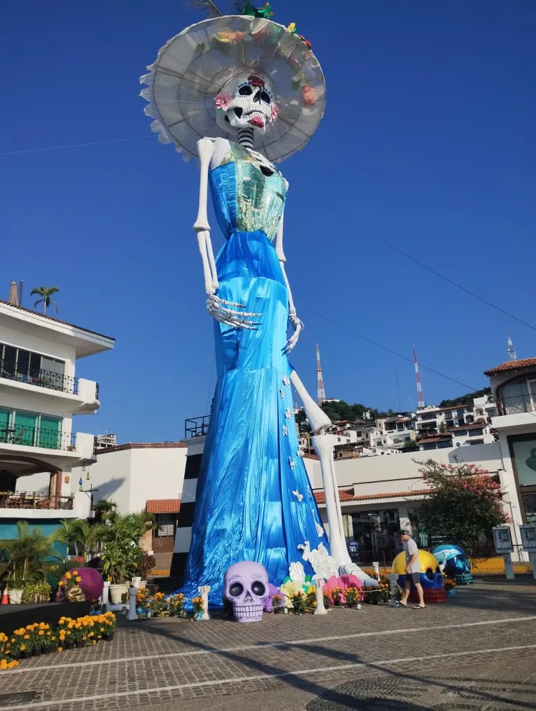 Tall Catrina costume figure with hat and painted skull face
